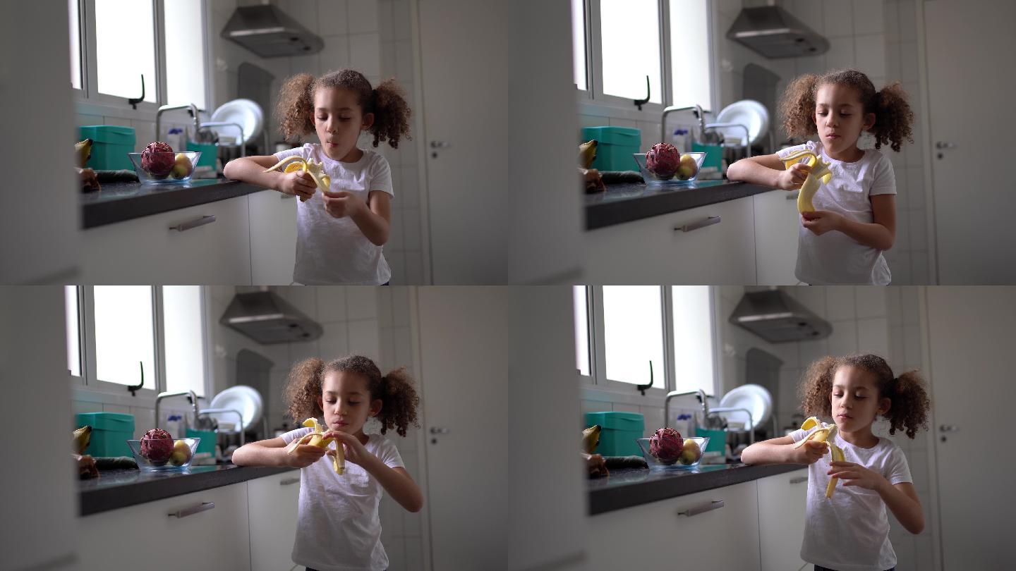 小女孩在家的厨房里吃水果