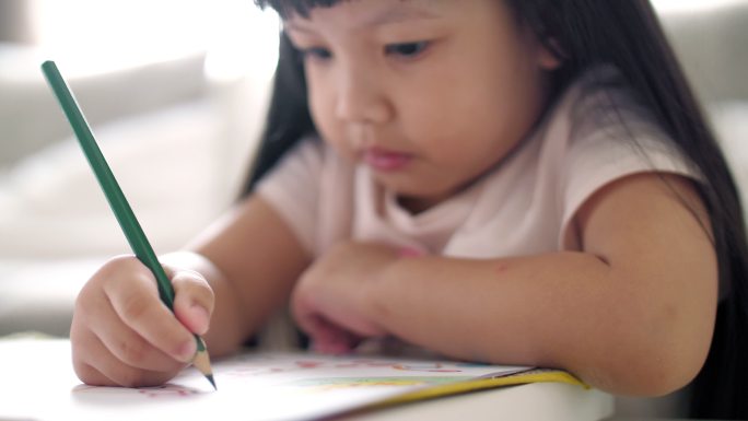 小女孩在家里画册上写字，慢动作
