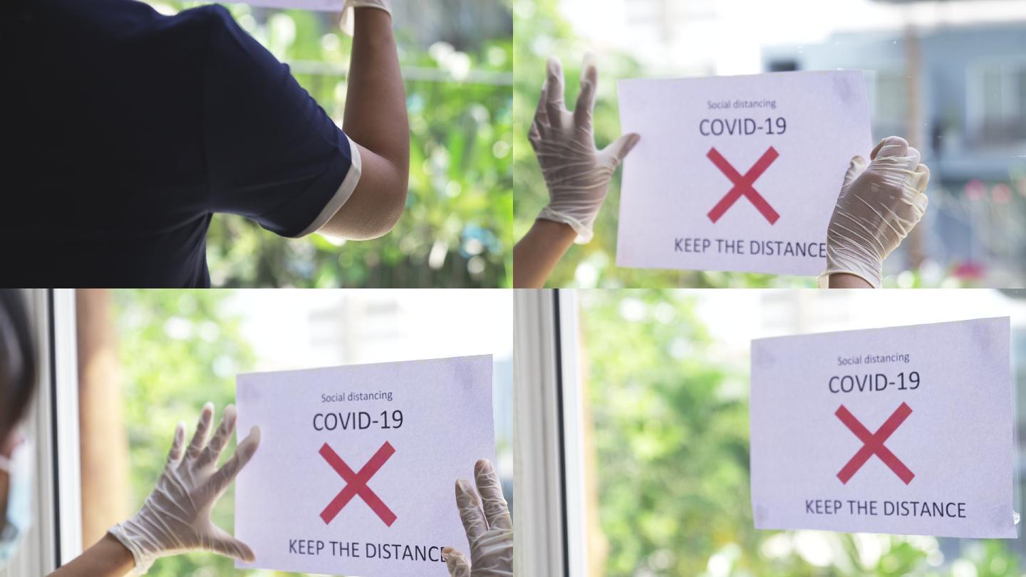 酒店工作人员戴着白色手套，提起带有警告的纸标签，以保持距离。预防新冠病毒-19。