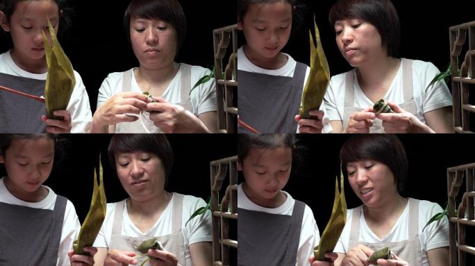 4K升格中国传统教女儿手工包制粽子的母亲