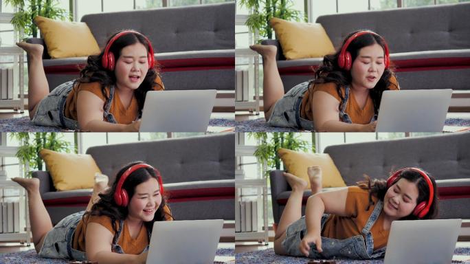 身材高大的女人在家里用笔记本电脑工作，亚洲女孩喜欢在家里的沙发上吃东西