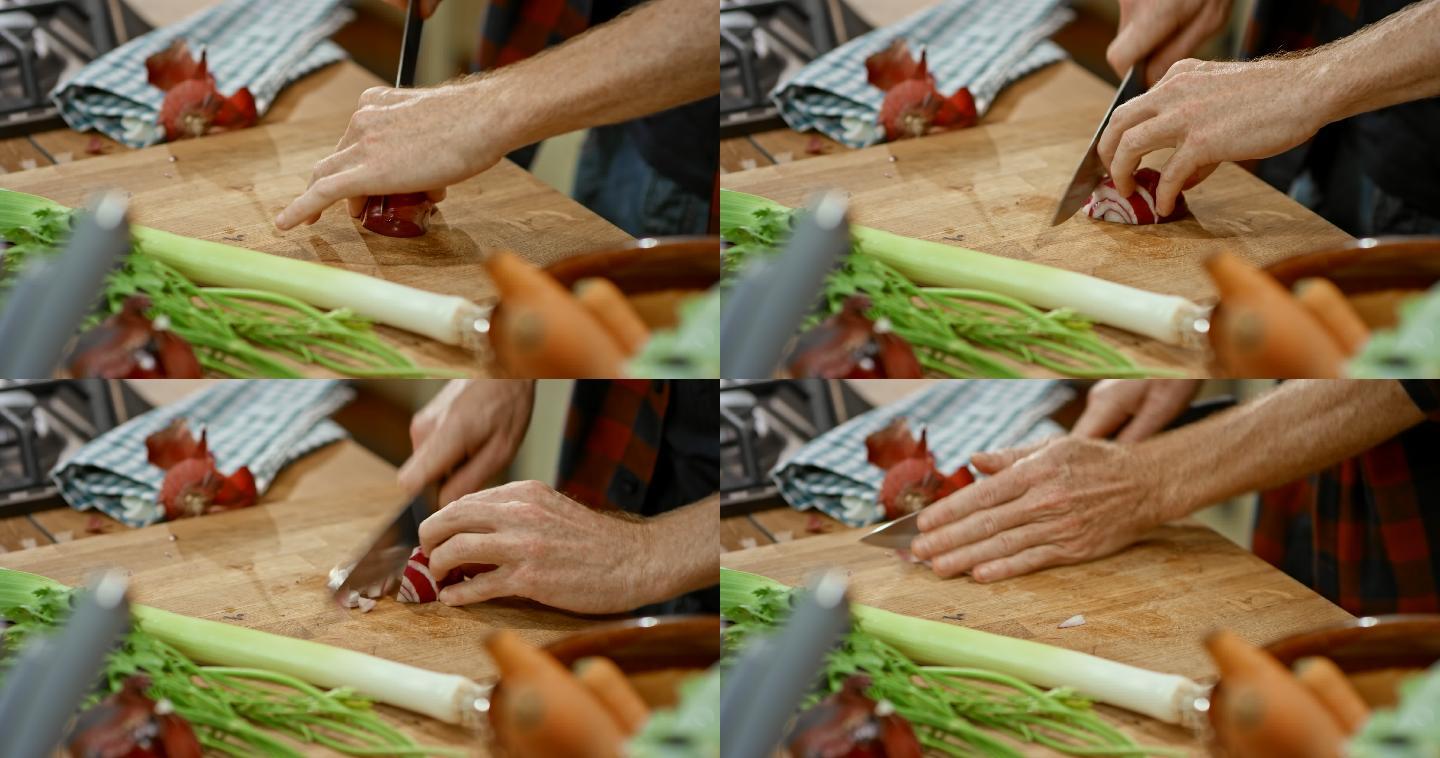 男厨师的双手在厨房的木板上切红洋葱