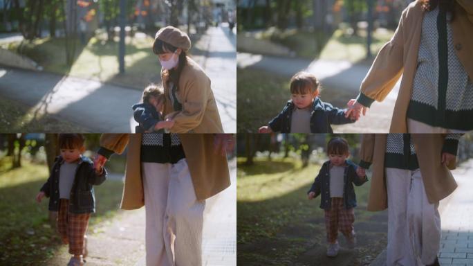 冬天，在阳光明媚、温暖的日子里，母亲和小女孩一起在城里散步和消磨时光。母亲戴防护口罩，防止奥米克罗或