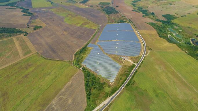 保加利亚农田之间的太阳能电池板田地。绿色/清洁能源、太阳能、可持续能源发电厂和可持续资源的概念，上升