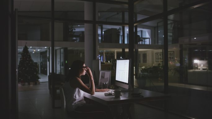 4k视频片段，一名年轻女商人在夜间办公室工作时看起来很紧张
