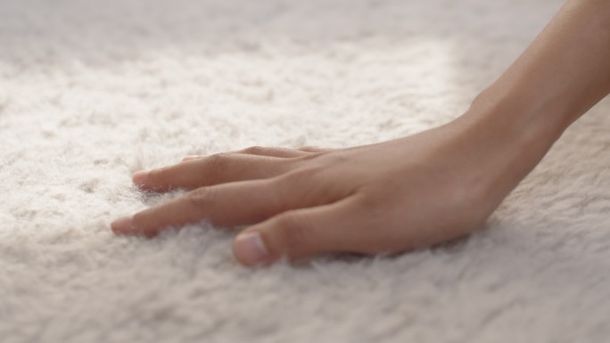 用手触摸柔软地毯的特写镜头，蓬松柔软舒适。