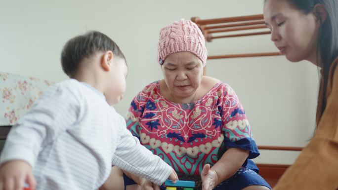 癌症祖母与孙子玩玩具积木