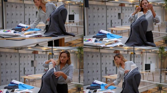 一位年轻美丽的女时装设计师在车间里为人体模型上的夹克进行测量