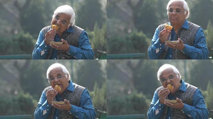 快乐老人在公园吃填充蔬菜泡芙