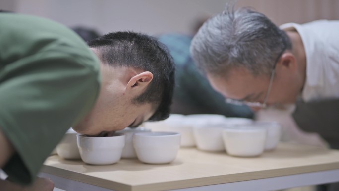 3名专业亚裔中国男咖啡师品酒师品酒后在剪贴板上记录咖啡杯