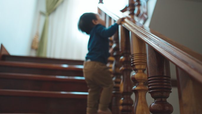 可爱的蹒跚学步的男孩走上楼梯