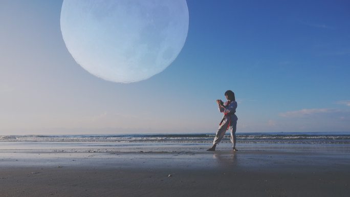 4k：以满月为背景，年轻女子在海滩上户外练武