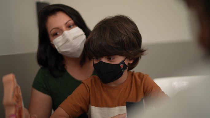 医生带着孩子的母亲在一家诊所看病-戴口罩