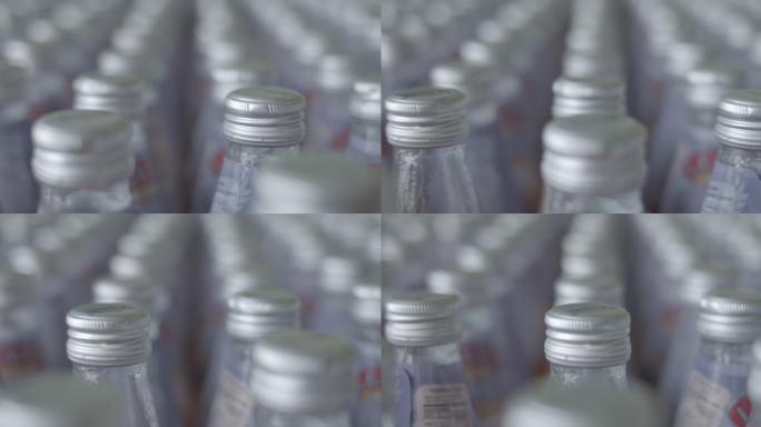 跟踪拍摄，大量果汁瓶排在生产线上，无人
