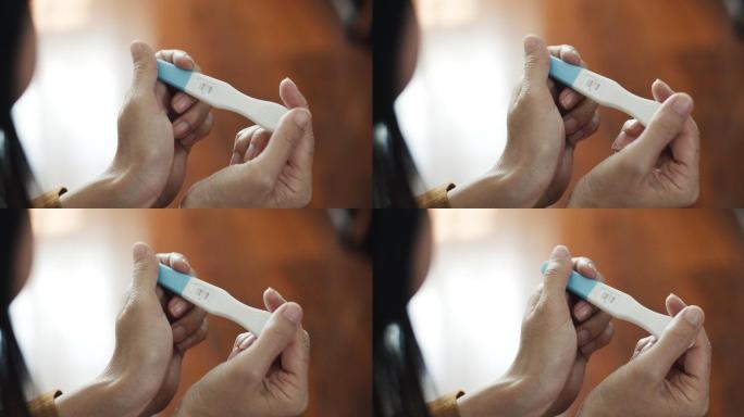 亚洲孕妇在卧室进行妊娠试验呈阳性