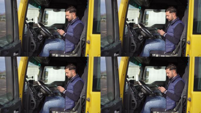卡车司机坐在卡车停靠站的驾驶室里使用电话