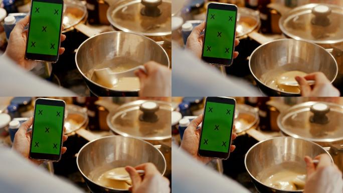 厨师用双锅法和手机在厨房准备酱汁