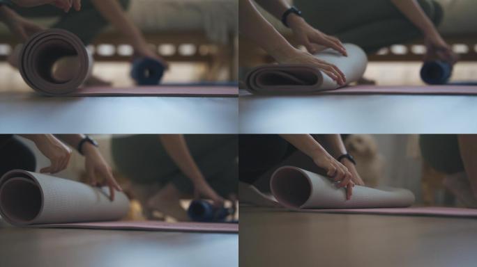 慢动作特写女性手展开瑜伽垫准备周末在家和朋友一起上瑜伽课