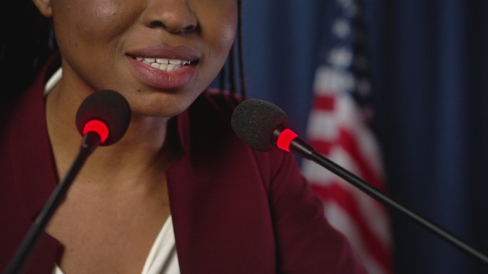年轻的非裔美国政治家以美国国旗为背景发表演讲