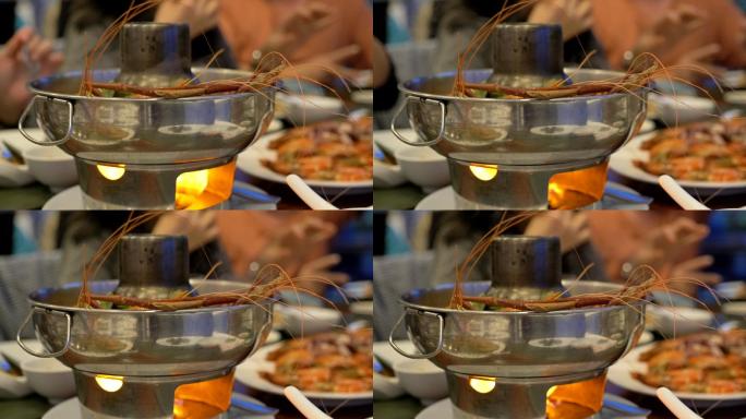 泰国辛辣食物慢镜头汤姆任功在餐厅的桌子上，人们在餐厅吃泰国食物