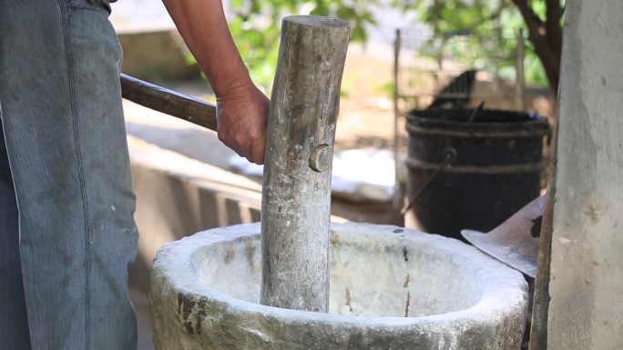 老人手工制作木船用石臼捶打石灰桐油苎麻