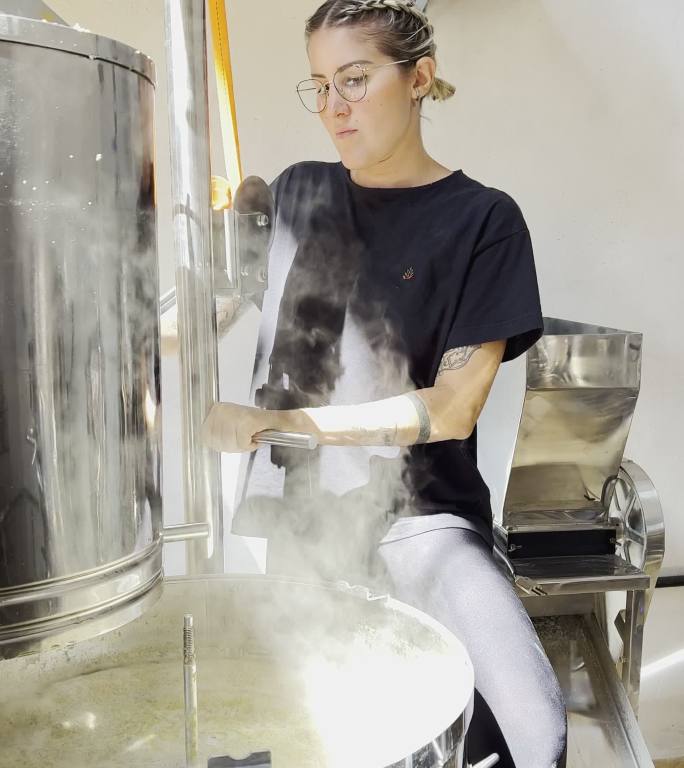 工艺啤酒企业家在啤酒酿造过程中拔出大麦罐