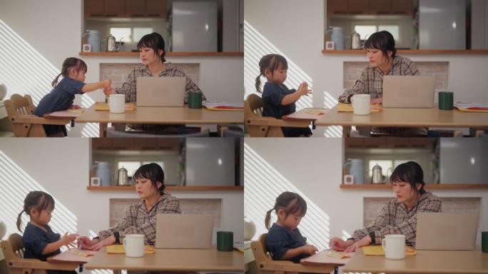 小女孩坐在母亲旁边，母亲在家里用笔记本电脑工作