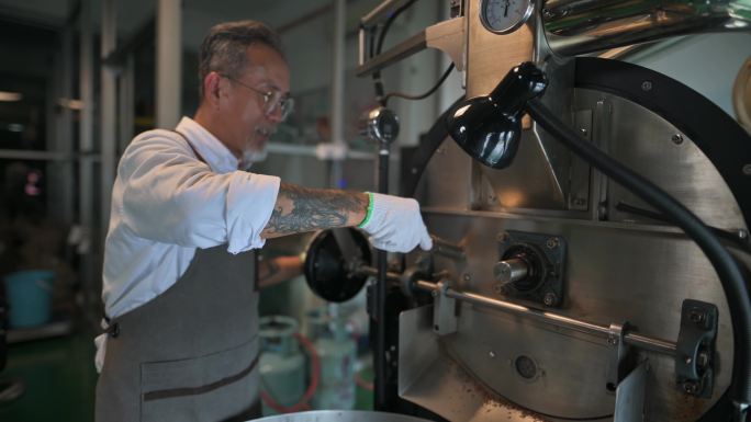 亚裔中国高级工匠微笑着拿着提尔从咖啡烤箱中提取咖啡豆烘焙生咖啡豆气味检查