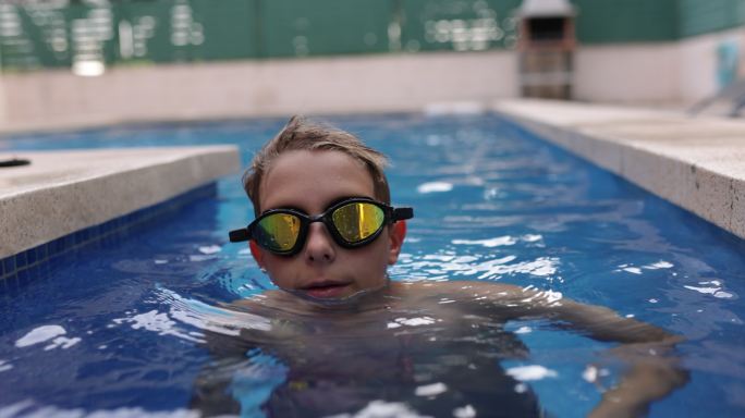 一个十几岁的男孩在游泳池里跳舞的肖像