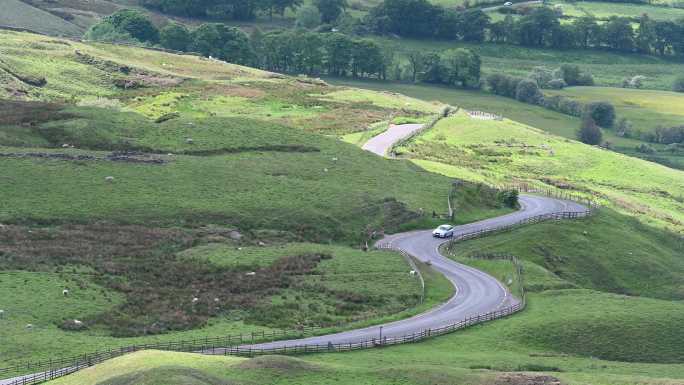 英国弯弯曲曲的乡村道路上行驶的独行汽车