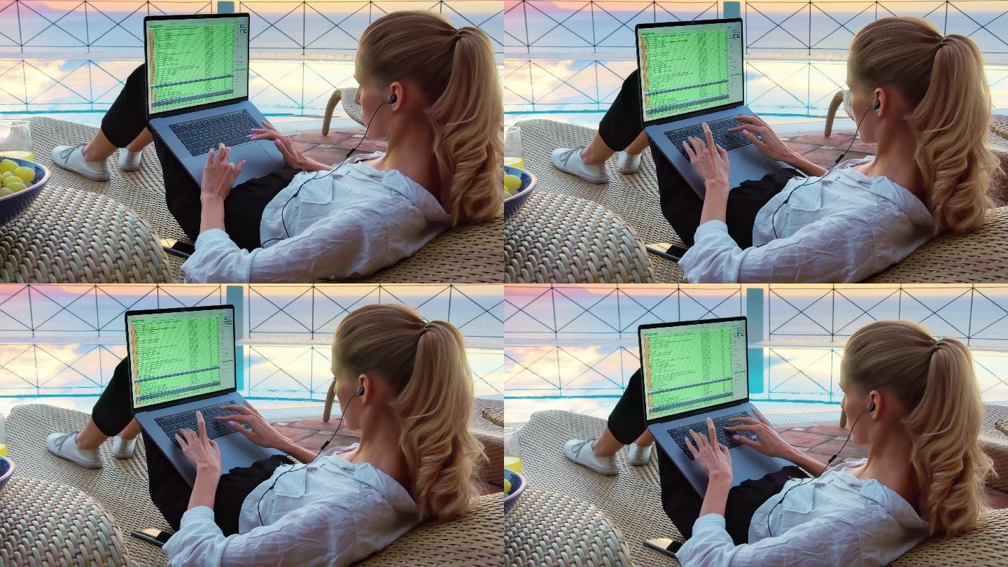 在院子里工作的女人。使用笔记本电脑欣赏史诗般的海景
