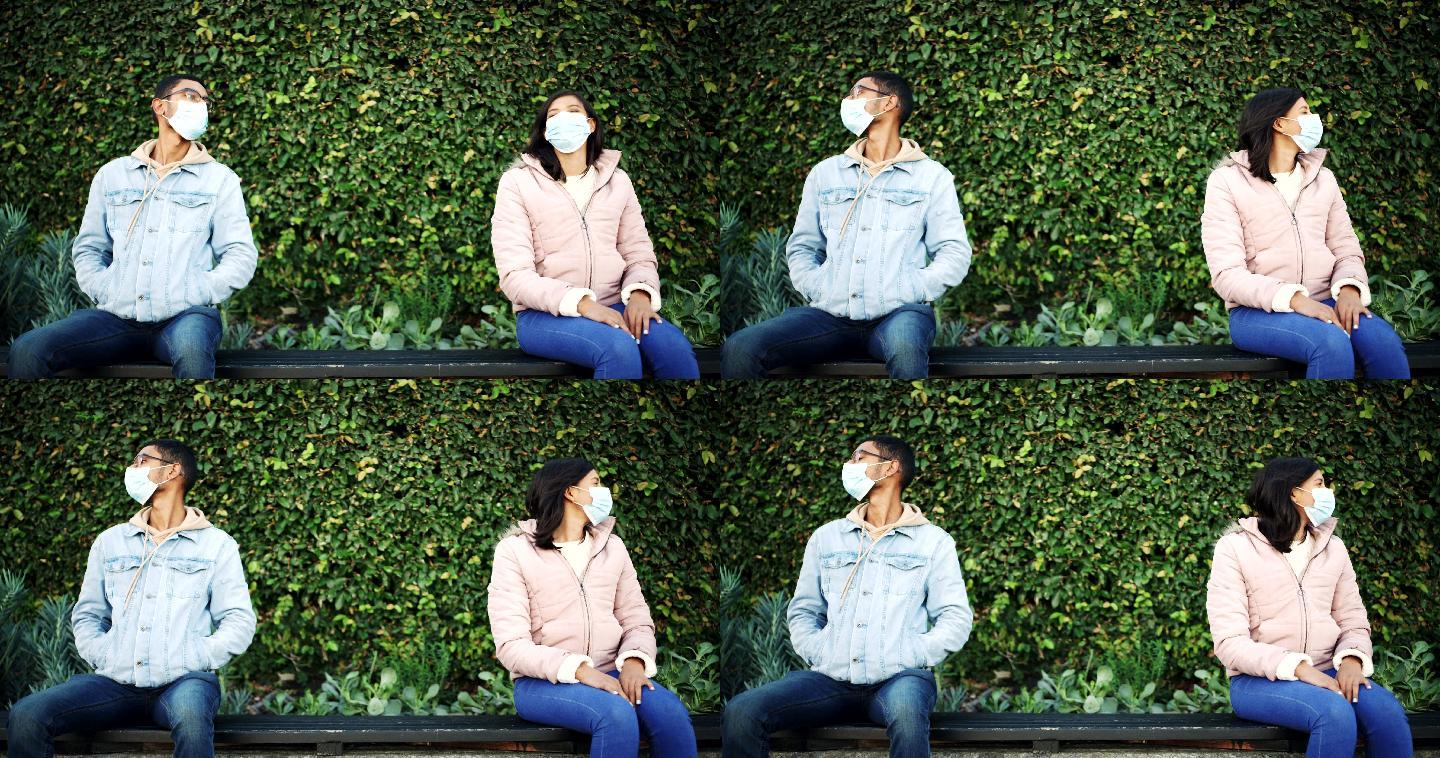 一对戴面具的年轻男女在公园里约会时分开坐着的4k视频片段