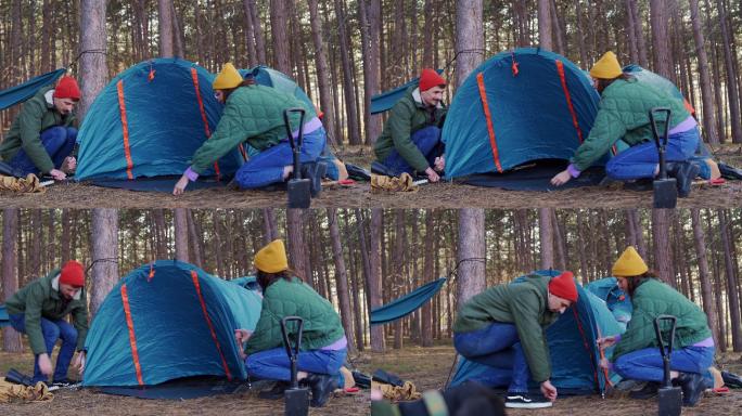 一对年轻的异性恋情侣搭起帐篷露营