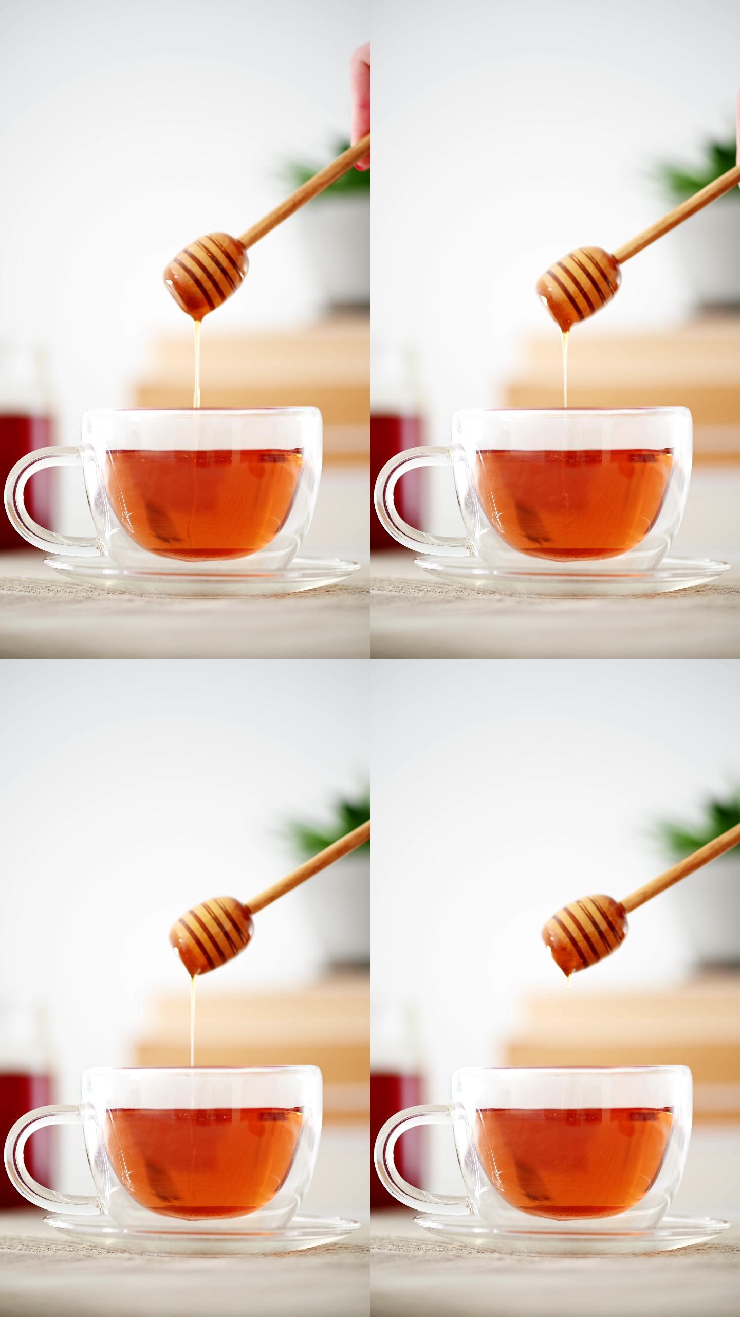 慢动作蜂蜜从蜂蜜勺滴入茶杯