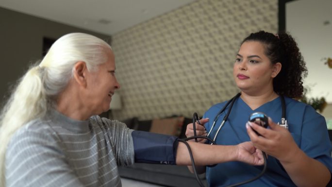 护士在家测量一位老年患者的血压