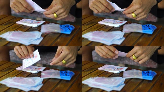 亚洲男子将政府彩票放入塑料信封中