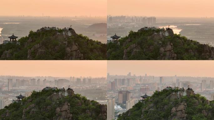 济南华山之巅赏日落的游客，晚霞中的城市