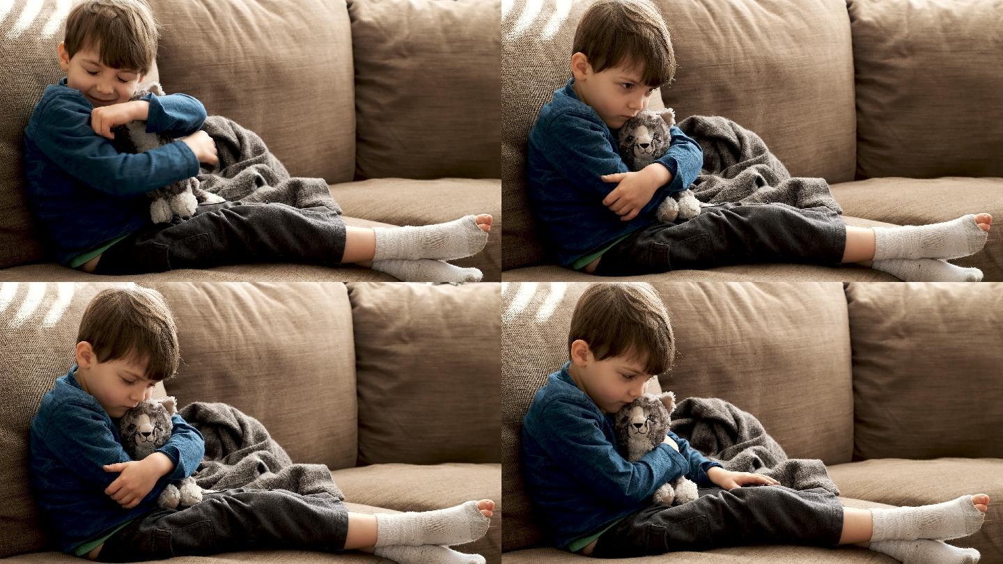 严肃沉思的小男孩抚摸着他的玩具猫