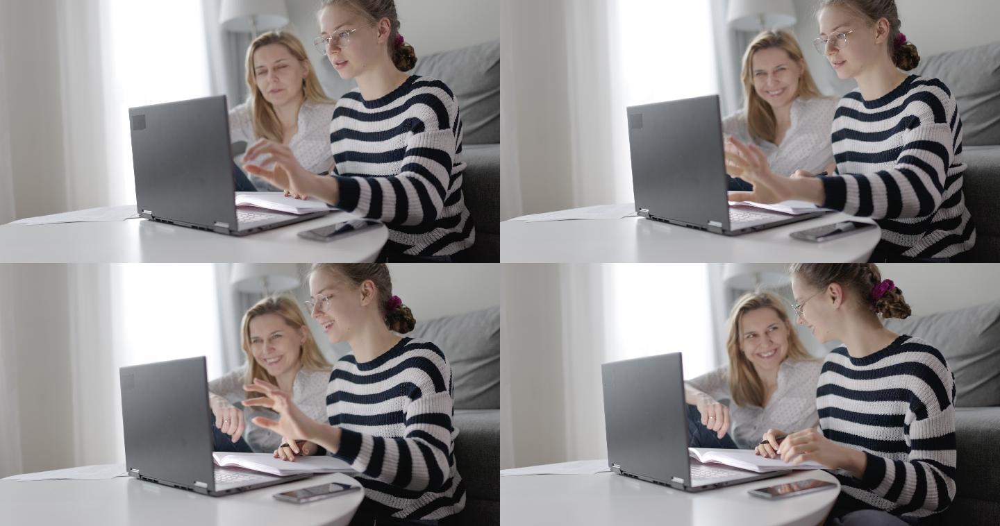 母亲和少女一起使用笔记本电脑