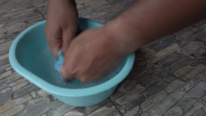 K特写镜头。男人在塑料盆里洗手