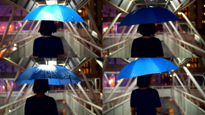 带着雨伞在人行天桥上行走的女性