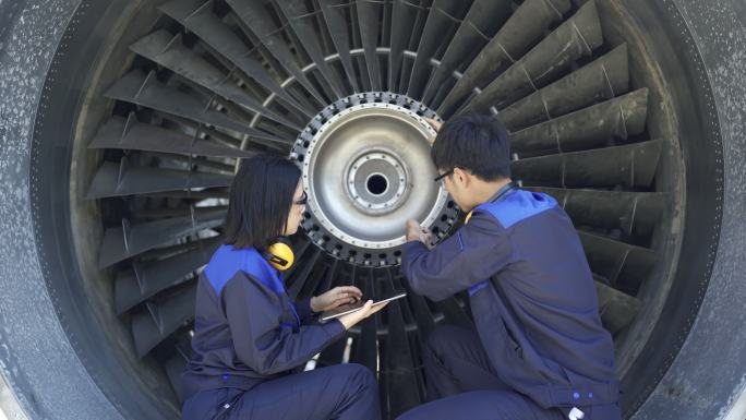 飞机工程师使用数字平板电脑维修喷气发动机