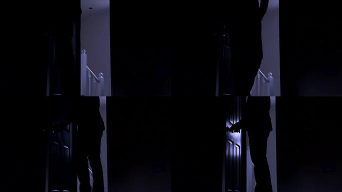 从左到右，一个男人离开黑暗房间的剪影。