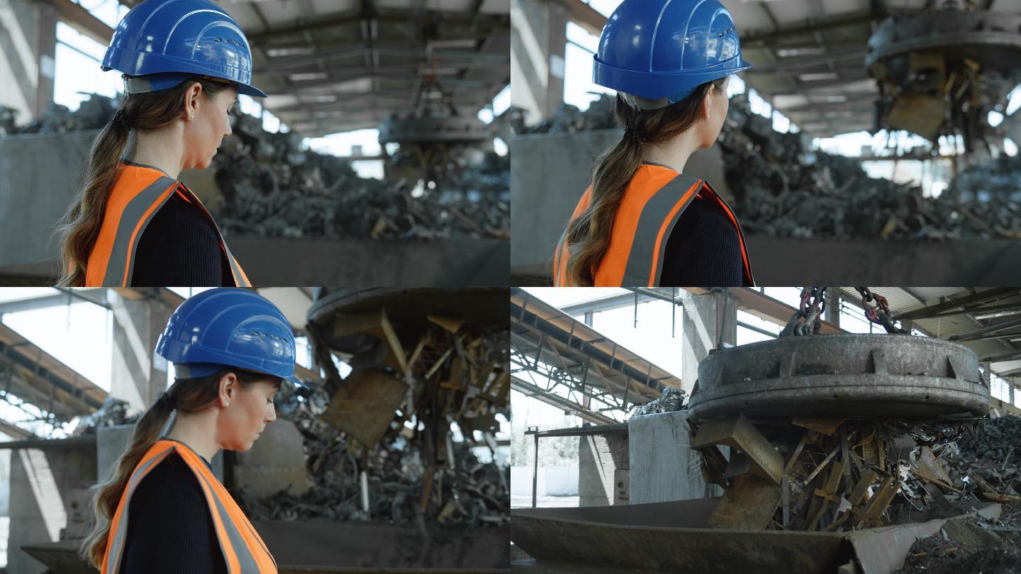 DS女性碎纸机运营经理站在金属回收设施的碎纸机旁