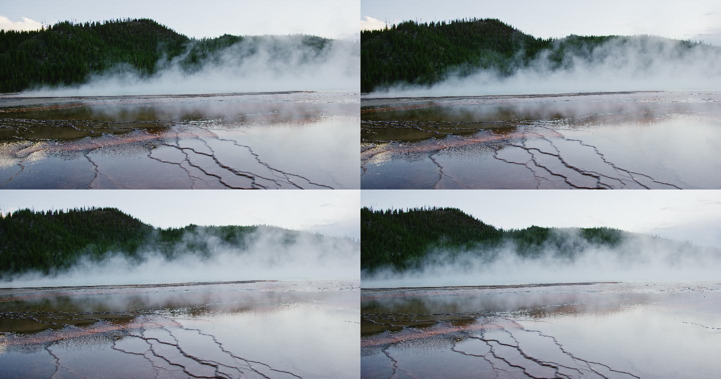 怀俄明州黄石国家公园的一片森林附近，大棱柱形温泉的热水冒着蒸汽
