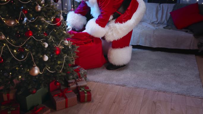 在一间现代公寓里，圣诞老人晚上把礼物放在客厅的圣诞树下。