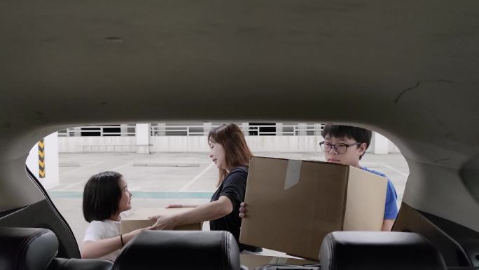 亚裔华人家庭在搬回家时从车上提着箱子