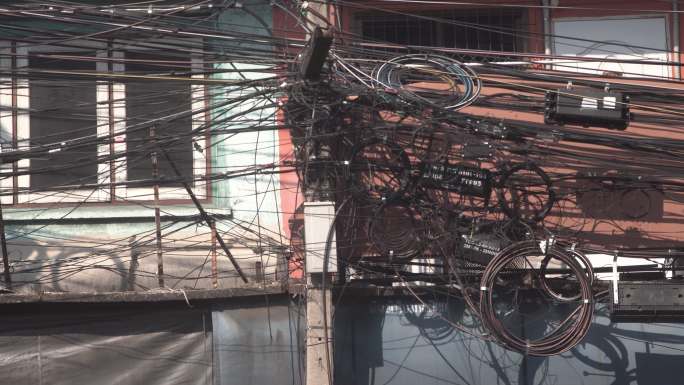 泰国曼谷街头凌乱的黑色电线，包括电线和电话通讯电缆。