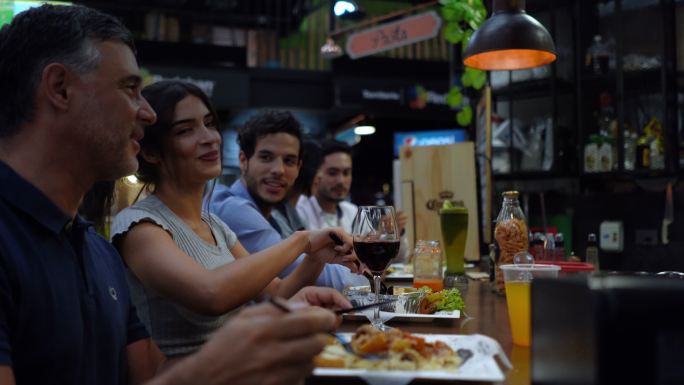 拉丁美洲朋友在餐厅享受美味午餐，谈笑风生