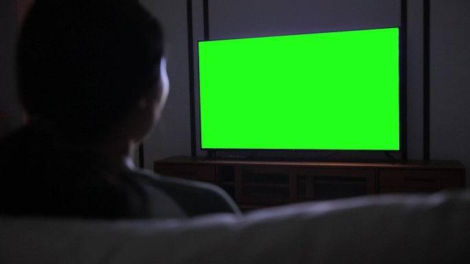 用绿色屏幕看电视的女人